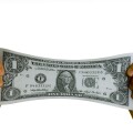 dollar bill USA stretched between two hands. Image shot 2007. Exact date unknown.