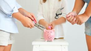 Kids with screwdriver, pliers and hammer by the pink pig piggy bank on a white background