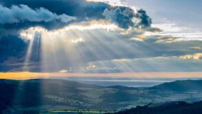 Shafts of light break through the cloud layer over Exmoor, bringing the hope of fine weather.