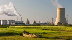 A chemical plant on the bank of the Humber estuary with derelict boat beached in the mud bank.