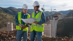 Construction workers looking at blueprint at construction site