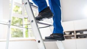 Low Section View Of A Handyman's Foot Climbing Ladder