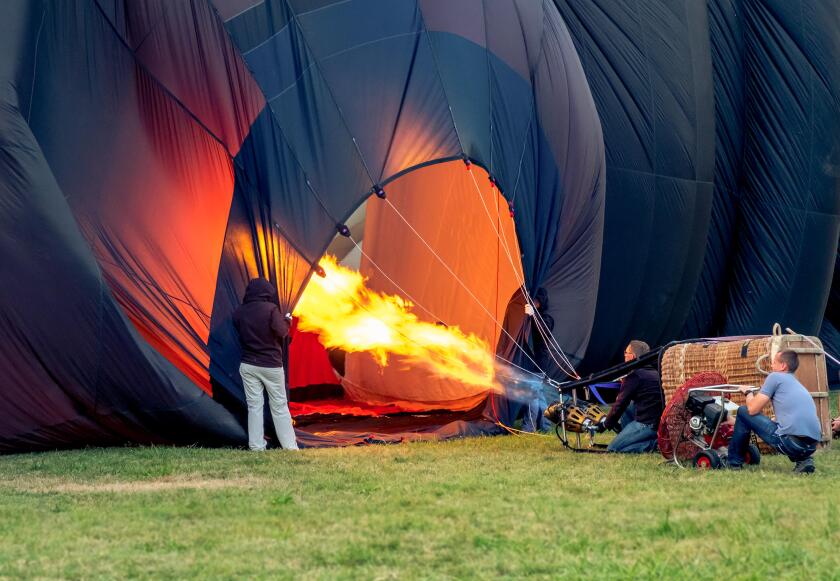 hot air balloon pilots inflating hot air balloon with the burner and the fan