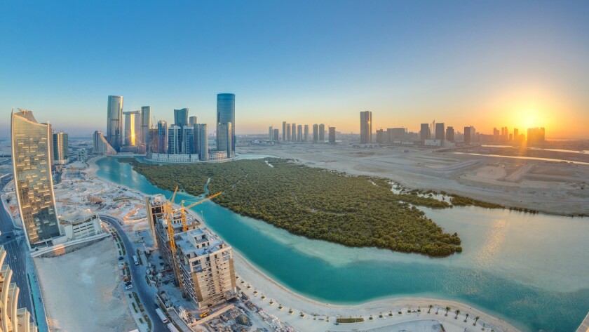 Buildings on Al Reem island in Abu Dhabi at sunset timelapse from above.