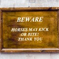 Beware, horses may kick or bite warning sign outside Horse Guards Parade on Whitehall, London, UK