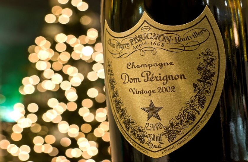 Bottle of 2002 vintage Dom Perignon luxury champagne with sparkling lights in background