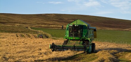 dh combine harvester HARVESTING UK John Deere Combine harvester cutting barley Orphir Orkney harvest fields scotland machinery farm machine. Image shot 2007. Exact date unknown.