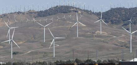 Tehachapi, CA. April 30, 2017. A cargo train passes beneath windmills in the Tehachapi Wind Resource Area, California's largest wind energy farm.