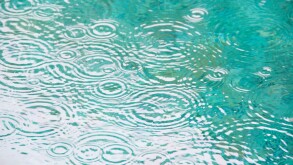 Brazil, Bahia, Trancoso, Raindrops on falling on pond surface