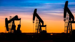Silhouette of Oil pumps at oil field with nice sunset sky background