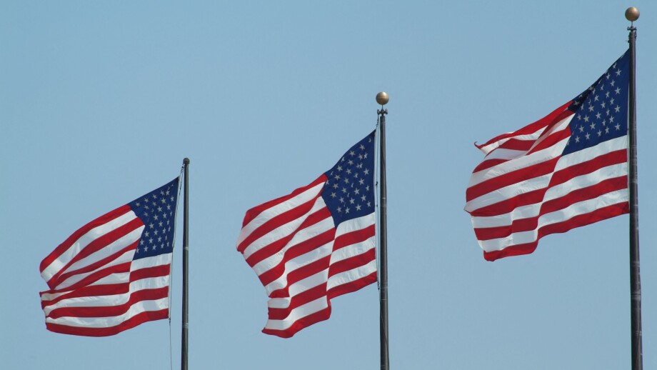 Stars and Stripes flags flying on three flagpoles United States of America USA