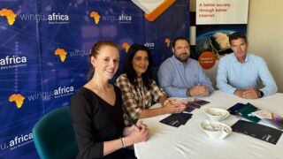 Wingu Africa staff sat in front of a stand