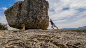 Man pushing a boulder on a rock