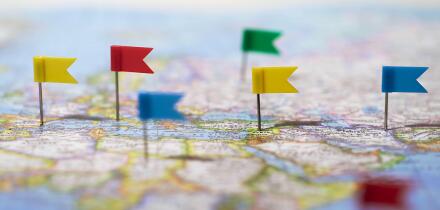 Many locations marked with pins on world map, global communication network