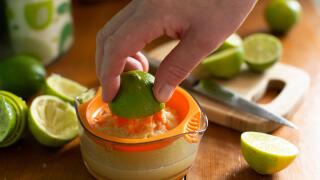 Caucasian hand squeeze lime on manual juicer