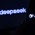 DeepSeek AI model displayed on a smartphone superimposed in front of a screen with the app logo blurred out