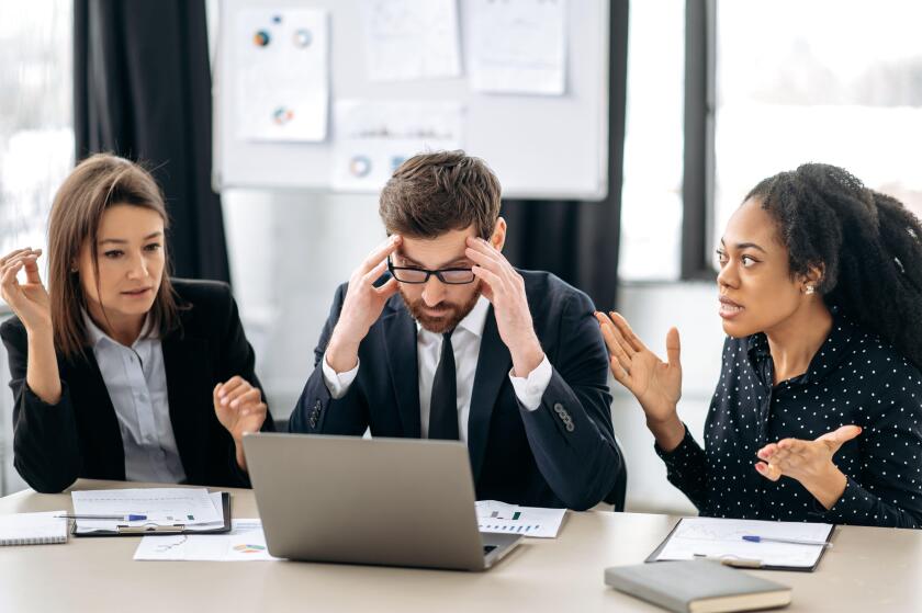 Annoyed business employees of different nationalities, work at the workplace in modern office, argue over work issues, cannot agree, experience stress from working together. Quarrel in the work team