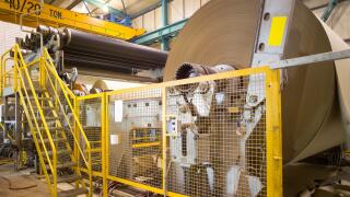 Big rolls of cardboard and paper coming out of the machinery in a paper mill plant in Chile.