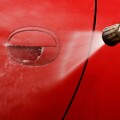 Cleaning the car with a pressure washer at jet wash