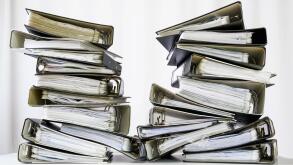 stacks of many ring binder with files, folders and documents on an office desk, concept for too much work and burn out in the business, selected focus