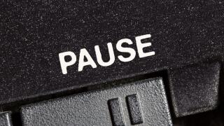 Macro close up photograph of vintage tape machine play and record pause button.