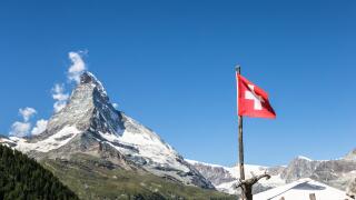 The Matterhorn and a Swiss flag above the famous village of Zermatt in Canton Valais in the alps in Switzerland