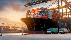 crane loading cargo container from truck to container ship in th