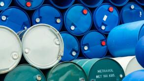 Old chemical barrels. Stack of blue methanol or methyl alcohol drum. Steel chemical tank. Toxic waste. Chemical barrel with toxic warning symbol. Industrial waste in drum. Hazard waste storage.