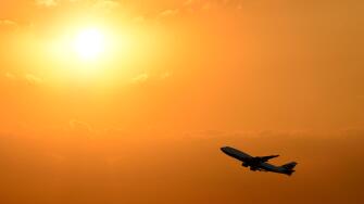 Airplane Taking Off Silhouetted Against a Sunset.