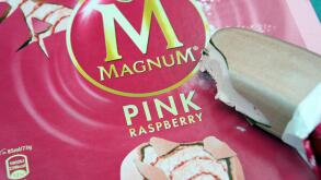 A Magnum Ice cream lolly with a bite out of it, in pink raspberry flavour.
