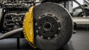 Automobile braking system. Ceramic carbon disk with perforation, ventilation and yellow calipers.