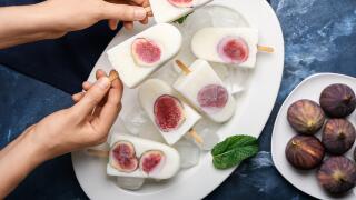 Woman with delicious fig ice-cream on color background