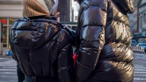 Pedestrians in Chelsea in New York wear Moncler brand parkas on Thursday, December 23, 2021  (© Richard B. Levine)