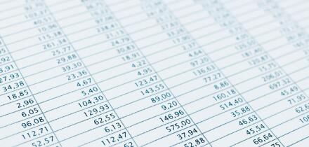 Business data report selective focus close up. Monthly stock stats spreadsheet. Blue toned.