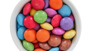 A bowl of Nestle smarties on a white background
