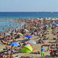 Crowded Barceloneta beach, hot summer day in Barcelona Spain.
