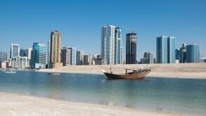 Traditional boat with modern skyline, Emirate of Sharjah, UAE.