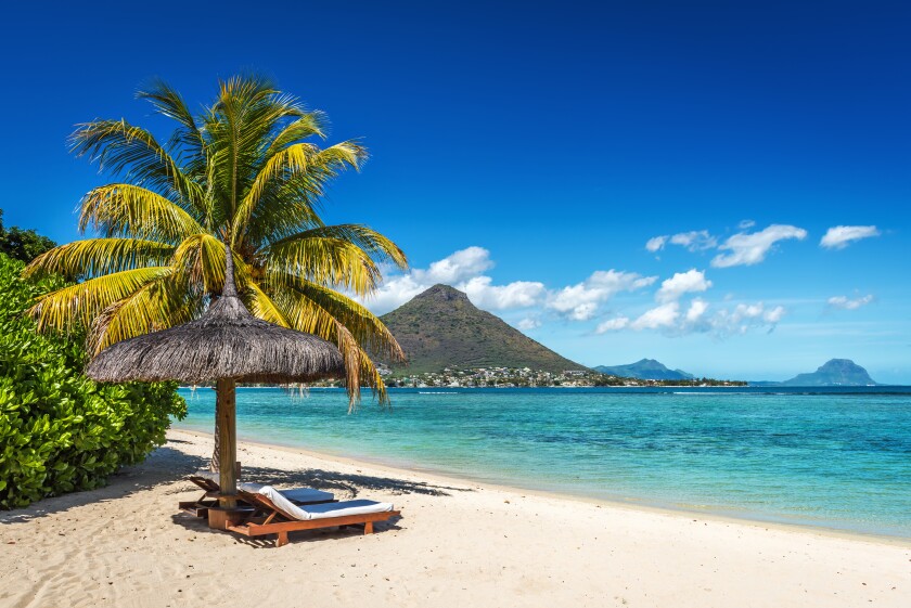 Loungers and umbrella on tropical beach in Mauritius