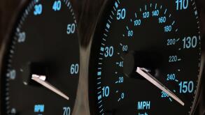 speedometer in car dashboard at full speed in illuminated night mode