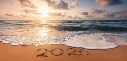 Happy New Year 2026 concept, lettering on the beach. Written text on the sea beach at sunrise.