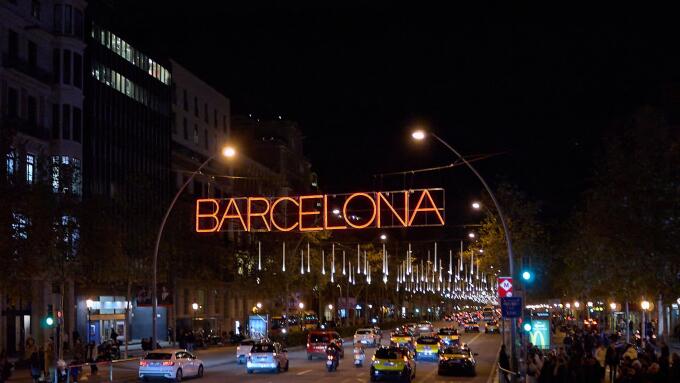 Barcelona. Spain - January 14, 2026: Night traffic on an iconic Barcelona street with taxis and decorative city lights.