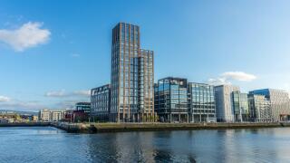 A scenic view of a glass buildings and the river in the modern part of Dublin Docklands, Ireland.