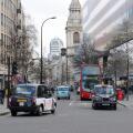 Black cabs, red bus and traffic between offices on Cheapside, City of London, UK