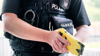 A British police officer holding a axon taser X2 conducted electrical weapon or stun gun. The taser is routinely issued to police forces across the uk