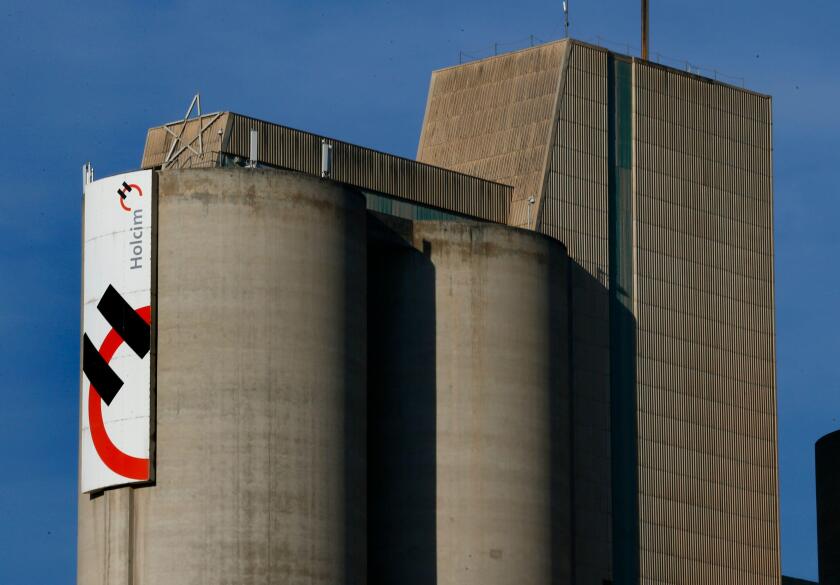 A Holcim logo is pictured on the cement works in Eclepens near Lausanne February 25, 2014. Holcim, the world's largest cement maker, will publish its annual result for 2013 on February 26, 2014. REUTERS/Denis Balibouse (SWITZERLAND - Tags: BUSINESS LOG