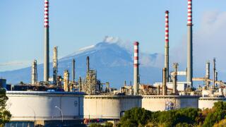 Railway by the Enel powerplant between Catania and Syracuse, Sicily, Italy, as the Mount Etna erupts