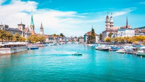 Panoramic view of Zurich city center with churches and boats on beautiful river Limmat in summer, Canton of Zurich, Switzerland