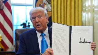 President Donald Trump holds an executive order regarding withdrawing from the United Nationals Human Rights Council in the Oval Office of the White House, Tuesday, Feb. 4, 2025, in Washington. (AP Photo/Evan Vucci)