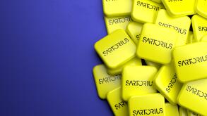 Logos of the pharmaceutical and laboratory equipment supplier Sartorius (member of DAX 40 as of Sept 2021) on a heap on a table. Copy space. Web banne