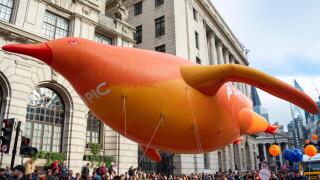 Pension Insurance Corporation float at the Lord Mayor's Show parade in the City of London, UK. Large inflatable penguin floating through City streets